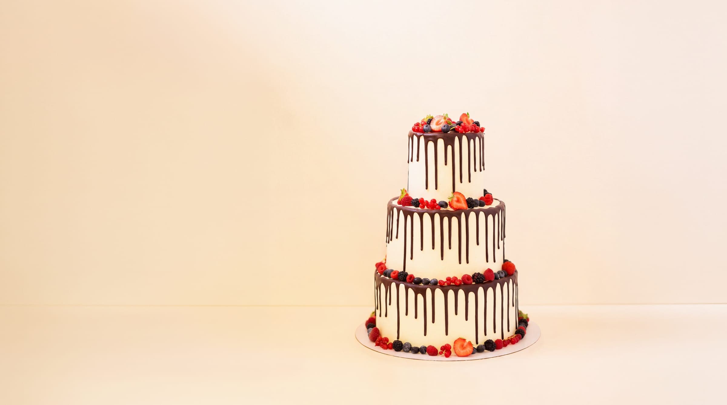 Dreistöckige Hochzeitstorte mit Schokoladendrip und frischen Beeren